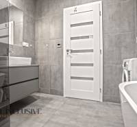 A bathroom in a 3-room apartment with white doors, a washing machine, and a sink.