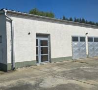 A white building with metal doors in the warehouse and hall zone of the city of Šaľa.
