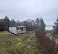 A cottage on Hlavná Street in Nová Kelča with a view of the water surface and forest.