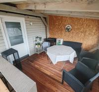Cottage on Main Street in Nova Kelca, terrace with wood-patterned flooring.