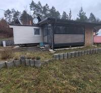 A cottage in Nová Kelča on Hlavná Street, surrounded by a lawn and curbs.