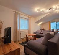 Living room in a holiday apartment with comfortable sofas and a wooden decor floor.
