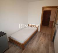 A bedroom with a bed, a dresser, and a floor with a wooden decor in a two-room apartment.