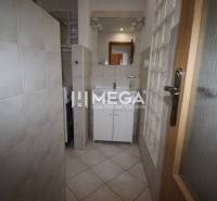 Bathroom in a 2-room apartment with a sink, mirror, and washing machine.