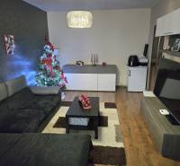 A living room decorated for Christmas in a three-room apartment with a wooden decor floor.