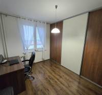 A room in a 3-room apartment with a desk and a floor with a wood decor.