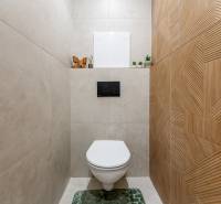 A toilet in a 2-room apartment with ceramic tiles and decorations.
