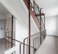 A staircase in an apartment building with white walls and metal railings.