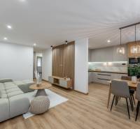 Living room with kitchen in a three-room apartment, wooden decor flooring, stylish lighting.