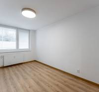 An empty room with a large window, white walls, and a wood-patterned floor in a 3-room apartment.