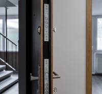 Open door to a 3-room apartment, showing a floor with a wooden decor and a window.