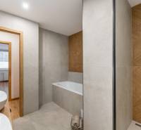 Bathroom in a 3-room apartment with a bathtub and double sinks, floor with wood decor.