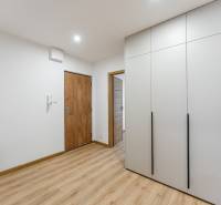 Entrance area in a 3-room apartment with wood-patterned flooring and built-in wardrobes.