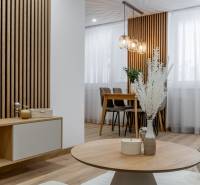 Design of a living room in a 3-room apartment with wood-decor flooring and stylish lighting fixtures.