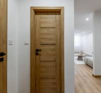 Interior of a 3-room apartment with a wooden decor floor and wooden doors.