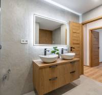A bathroom in a 3-room apartment with a double sink and a mirror with light.