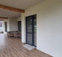 Terrace of a family house in Studienka with a swinging swing and furniture, flooring with a wooden decor.