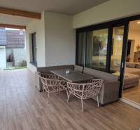 Terrace of a family house in Studienka with glass doors and a wooden decor floor.