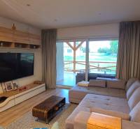Living room of a family house with a sofa, a large television, and a wooden decor floor.
