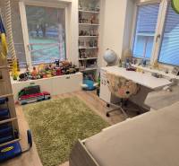 Children's room in a family house with toys, a table, and a floor with a wooden decor.
