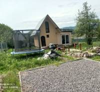 Cottage in Hliník nad Hronom with a trampoline and a gravel path in the garden.