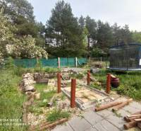 A garden by the cottage in Hliník nad Hronom with a trampoline and a wooden walkway.