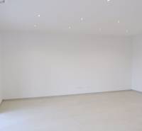 An empty room in a family house with white walls and a light floor.
