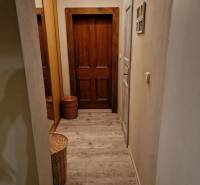 Hallway in a family house with doors and flooring featuring a wood design.