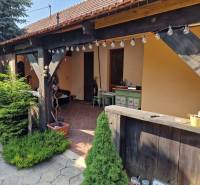 A family house in Dlhá nad Váhom with a terrace, wooden elements, and garden decorations.
