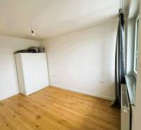 A room in a family house with a white wardrobe and a wooden decor floor.