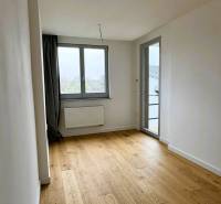 A room in a family house with a wooden decor floor and large windows.