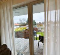 Interior of a family house with a view of the terrace and garden, floor with wooden decor.
