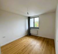 A room with a wooden decor floor, a window, a radiator in a family house.