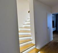 A staircase in a family house with built-in lighting and flooring with a wooden decor.