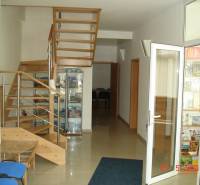 Interior of commercial premises with a wooden staircase and a glass display cabinet.