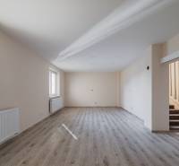 A spacious room with a wooden decor floor and a staircase in a family house.