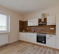 A kitchen in a family house with a wooden floor decor and a large window by the radiator.