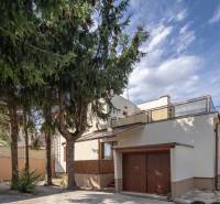 A family house on Trnovecká Street in Trnovec nad Váhom with a built-in garage and tall trees.