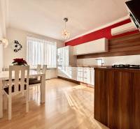 A kitchen in a 2-room apartment with a wooden decor floor and a dining table.