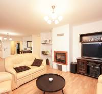 Living room in a family house with a fireplace, leather sofas, and a floor with a wooden decor.