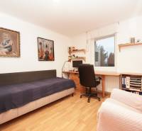 A children's room in a family house with a bed, a desk, and pictures on the walls.