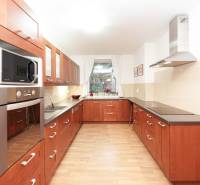 A kitchen in a family house with a wooden decor, with a cooktop and a microwave oven.
