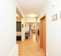 A hallway with a wooden decor floor in a family house, with a coat rack and a radiator.