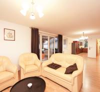 Living room of a family house with a cream sofa and a wooden decor floor.