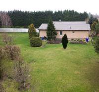 A family house on Hlavná Street in Kvetoslavov, surrounded by a large garden and coniferous trees.