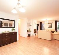 Living room with a fireplace and light furniture, wooden decor flooring, family house.