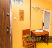 Interior of a 4-room apartment with orange walls, wooden furniture, and ornamental carvings.