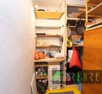 A small storage room in a 4-room apartment with shelves and stored items.