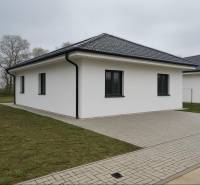 A family house in Cífer with a sloped roof and a paved walkway.
