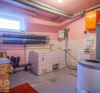 Laundry room in a family house with a washing machine, dryer, and storage space.
